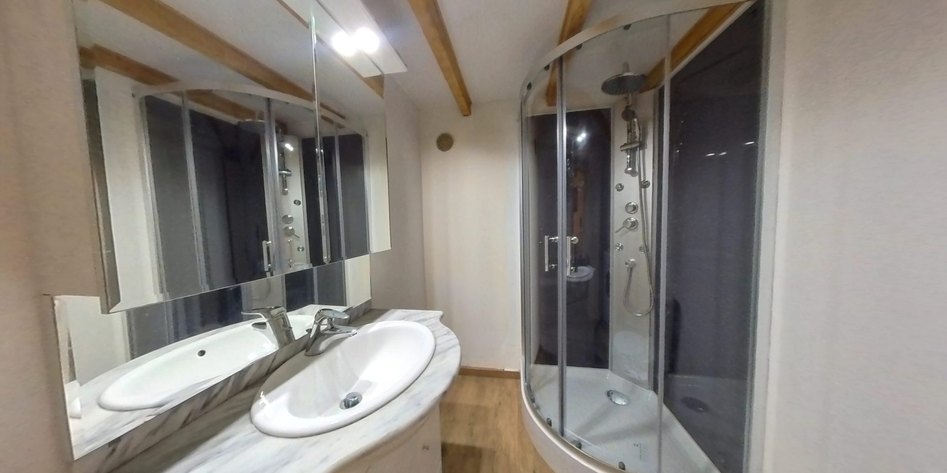 Vue de la salle de bain 1 composé d'une douche, un lavabo et un wc